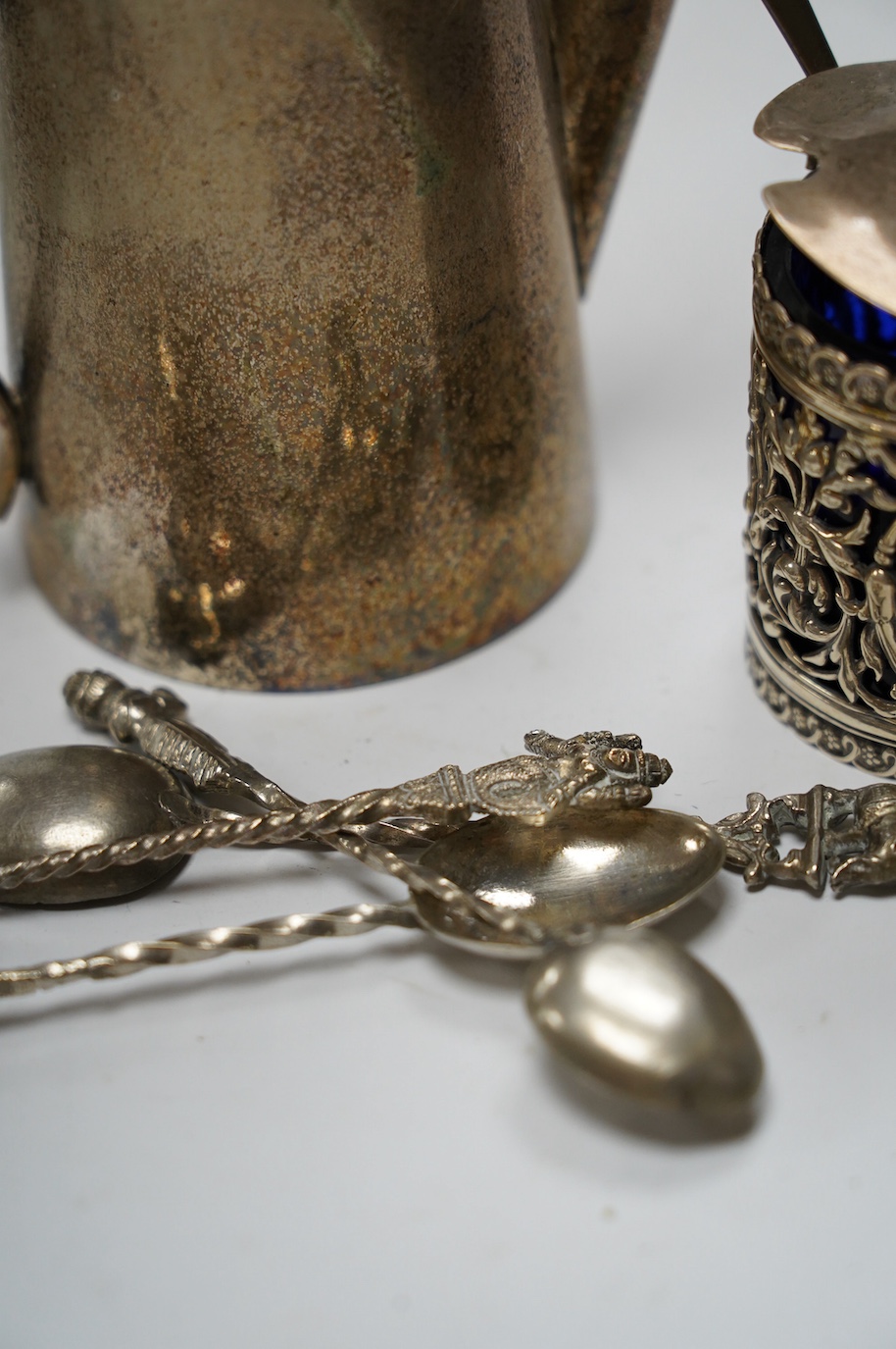 Small silver including a late Victorian pierced silver mustard pot, a small cream jug and oval trinket box, together with five metal spoons and a plated hot water jug. Condition - poor to fair